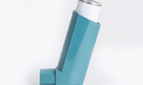 Person using an inhaler for icd-10 code for asthma treatment, managing symptoms and improving breathing.