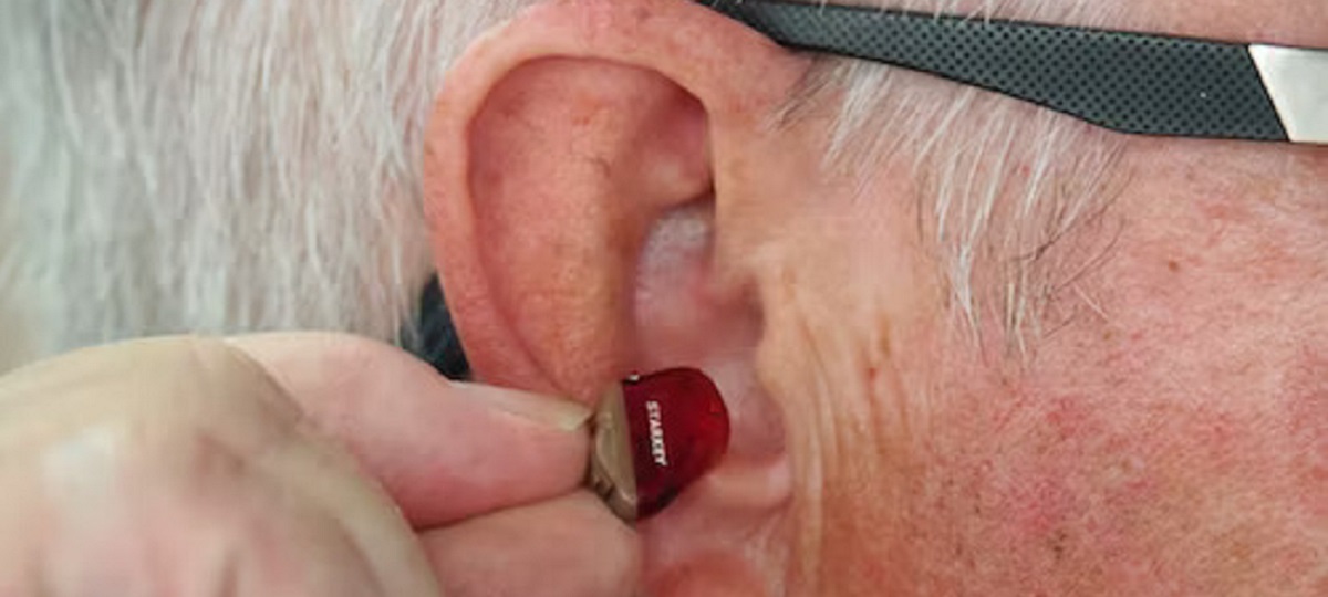 Man receiving ear seeding therapy for wellness