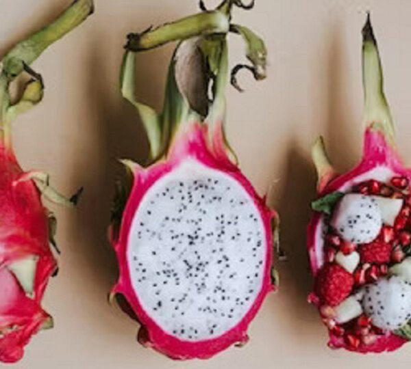 A halved dragon fruit with white flesh and black seeds, showcasing its sweet and refreshing taste.
