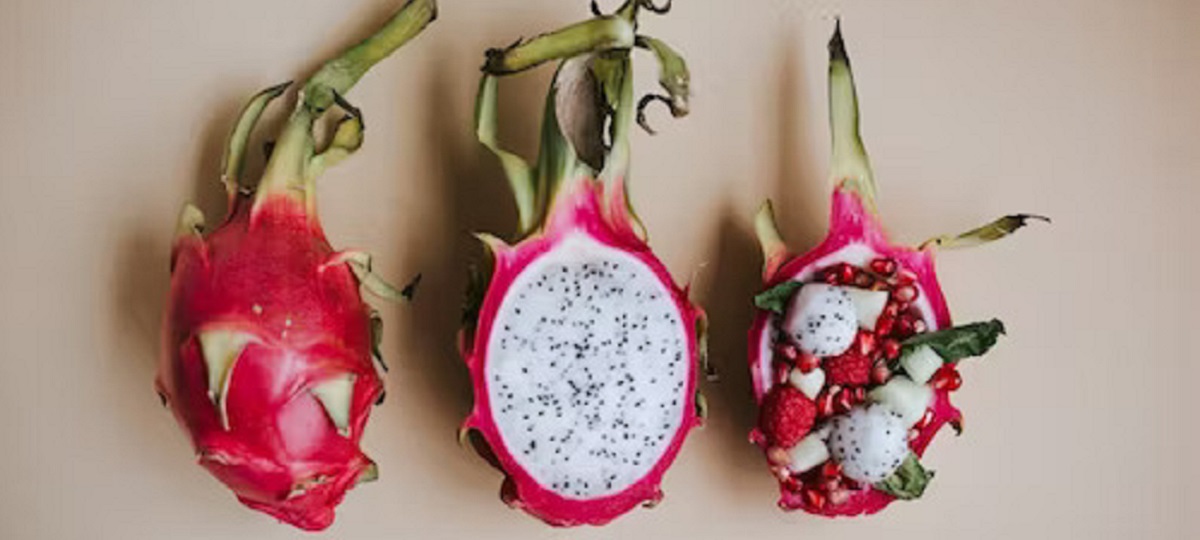 A halved dragon fruit with white flesh and black seeds, showcasing its sweet and refreshing taste.