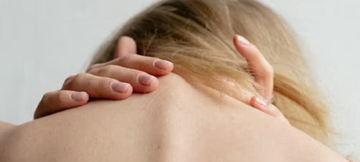 Woman practicing neck stretches in bed, following tips for relieving neck pain from sleeping wrong.