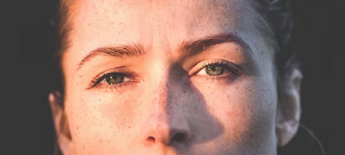 Woman practicing a gentle skincare routine to manage rosacea and seborrheic dermatitis on her face, using a mild cleanser and moisturizer.