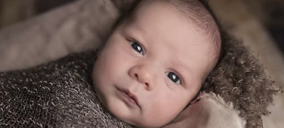 A close-up photo of a baby's face with small red bumps, depicting baby acne.