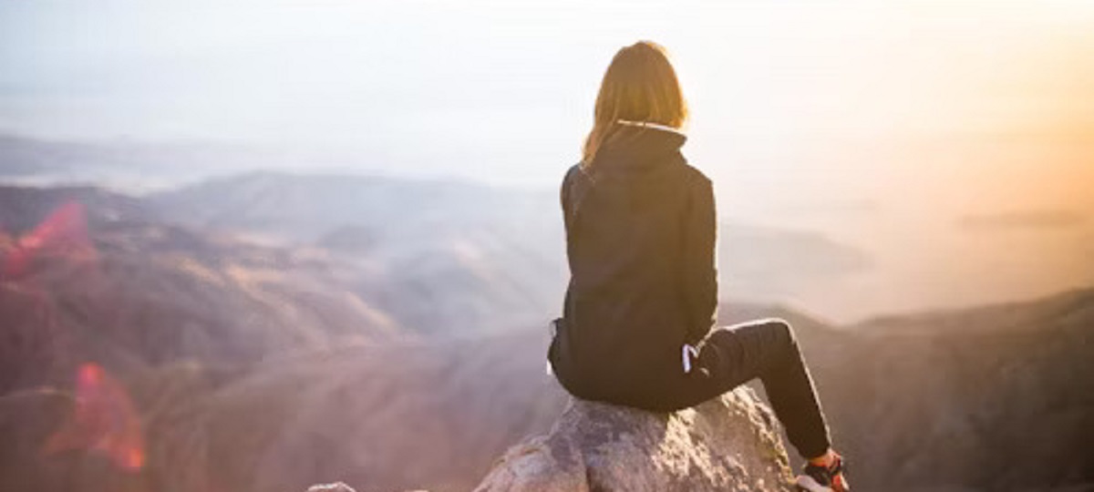 A person practicing mindfulness in nature, embracing wellness activities for mental health and a fulfilling life.