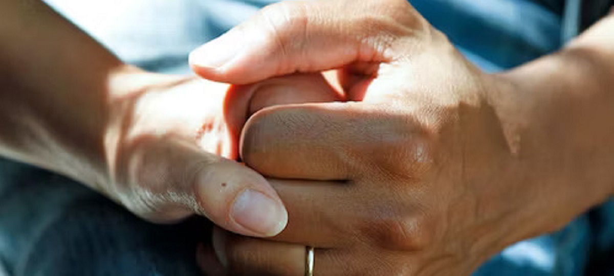 A caregiver assisting a person with Parkinson's disease in daily activities, highlighting the importance of treatment and support.